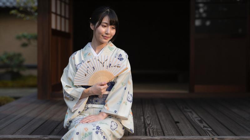 旅館の縁側で夕涼みする女性
