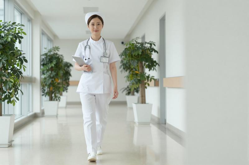病院の廊下を歩くベテラン看護師