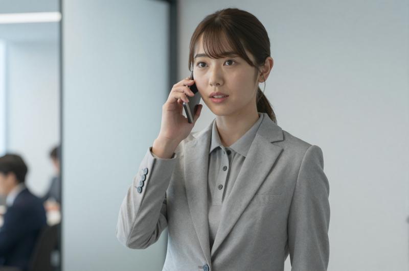 オフィスで真剣に電話する男性