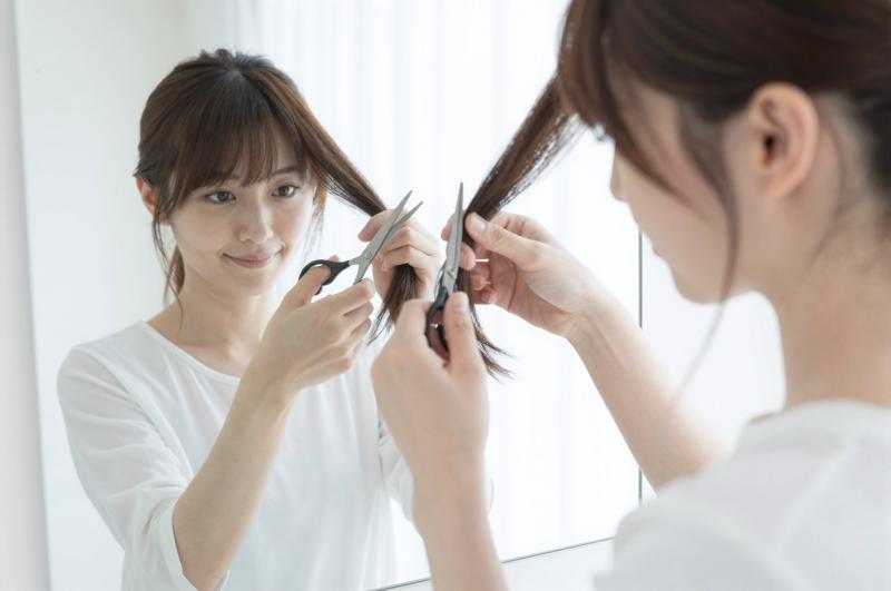 自宅で髪の毛をセルフカットする女性