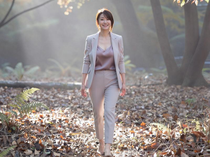 秋の森を歩くスタイリッシュな女性のポートレート