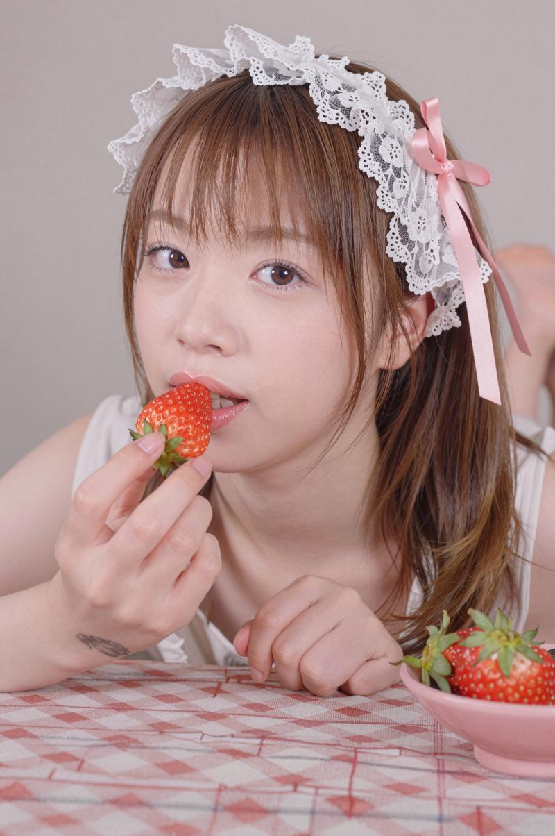 イチゴを食べる可愛らしい笑顔の女性のポートレート