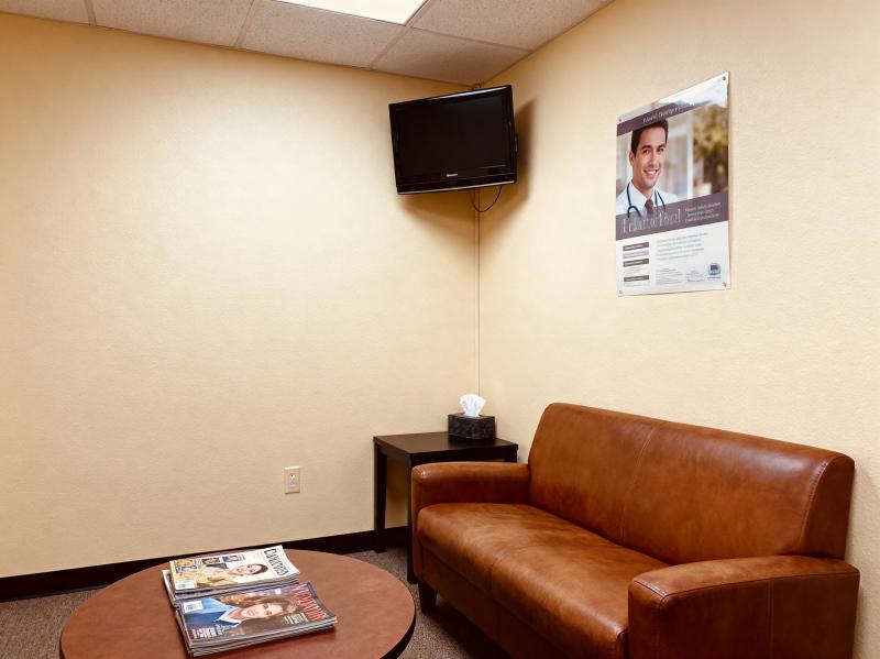 ベージュの壁と茶色の革張りのソファが置かれたモダンな待合室。