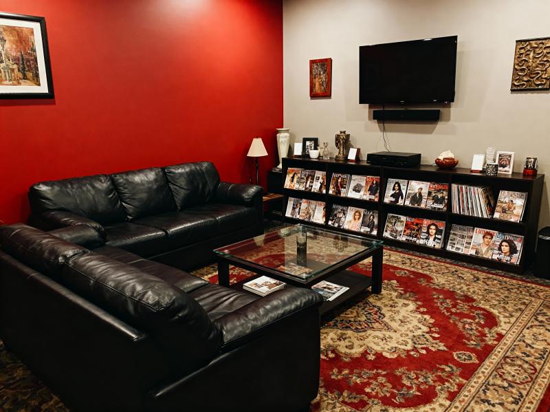 赤い壁と黒い革製の家具 (黒い革製のセクショナル ソファやガラスのコーヒー テーブル...。