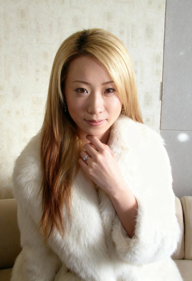 長くまっすぐなブロンドの髪と茶色の目をした、白い毛皮のコートを着た若い女性の肖像画。