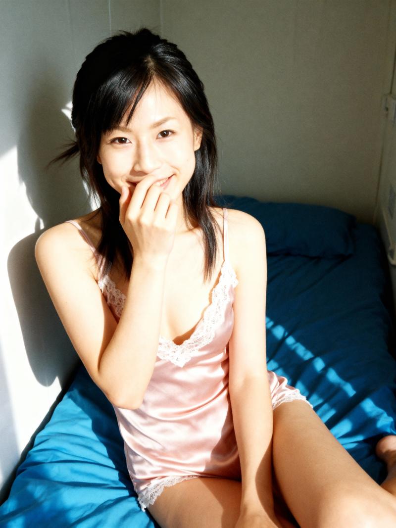 レースのトリムが付いたピンクのサテンのナイトガウンを着て、居心地の良い寝室のベッドに...。