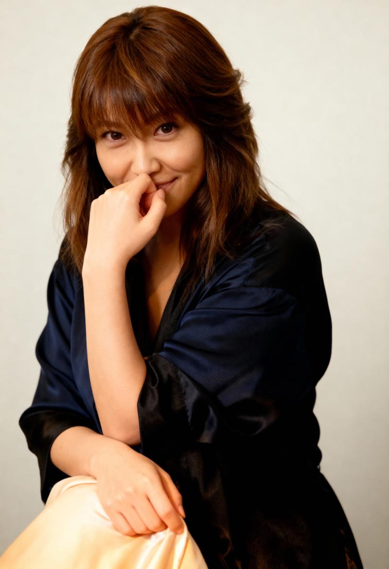 長い茶色の髪と思慮深い表情を持ち、あごを手に乗せてポーズをとっている若い女性を、ポー...。