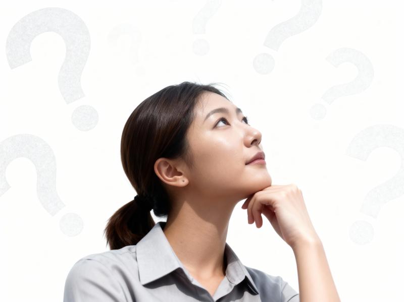 無地の白い背景に疑問符で囲まれた、思慮深い表情をしたアジア系の若い女性を横顔カメラの...。