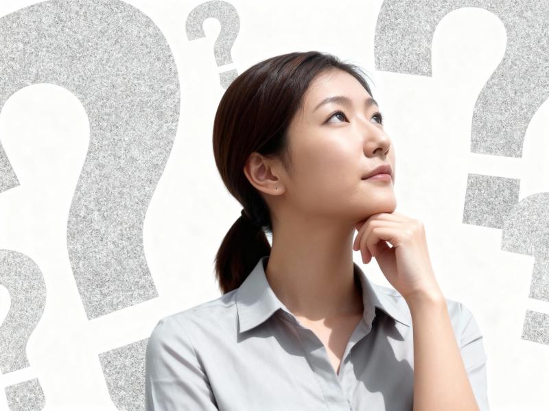 疑問符に囲まれ、思慮深い表情を浮かべたアジア系の若い女性を横顔カメラのアングルから写...。