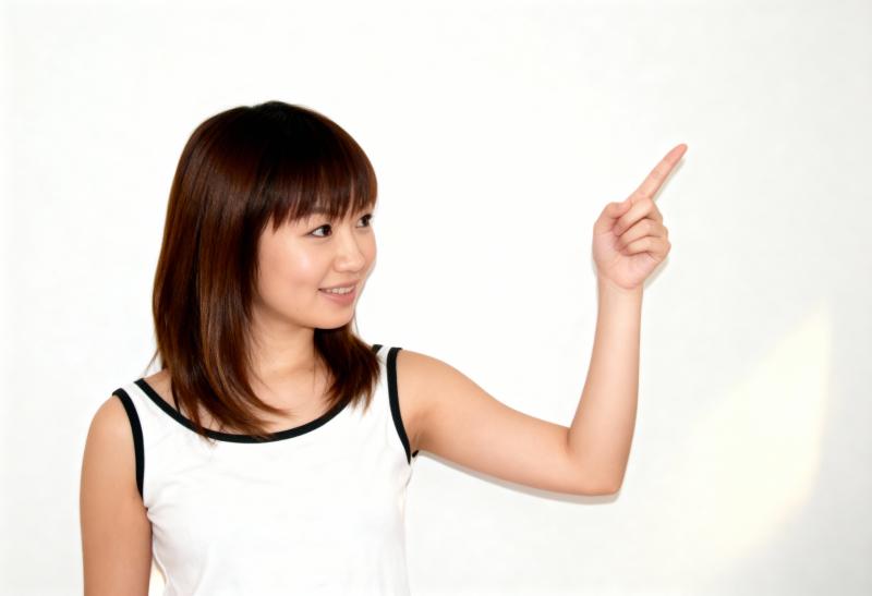 肩までの長さのストレートなボブヘアを持ち、人差し指を上に向けてわずかな笑みを浮かべた...。