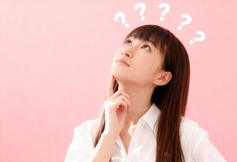 長い茶色の髪と頭上に浮かぶ疑問符に囲まれた思慮深い表情をした若い女性を横顔カメラのア...。