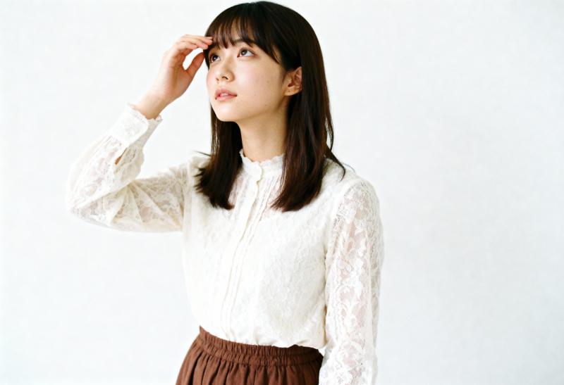 白いレースのブラウスと茶色のスカートを着た、思慮深い表情の若い女性を横顔カメラのアン...。