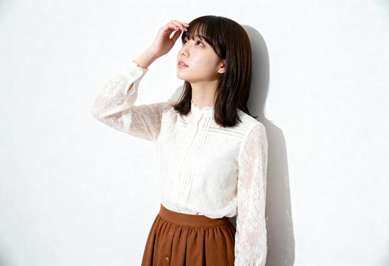 無地の白い壁に立っている若い女性。