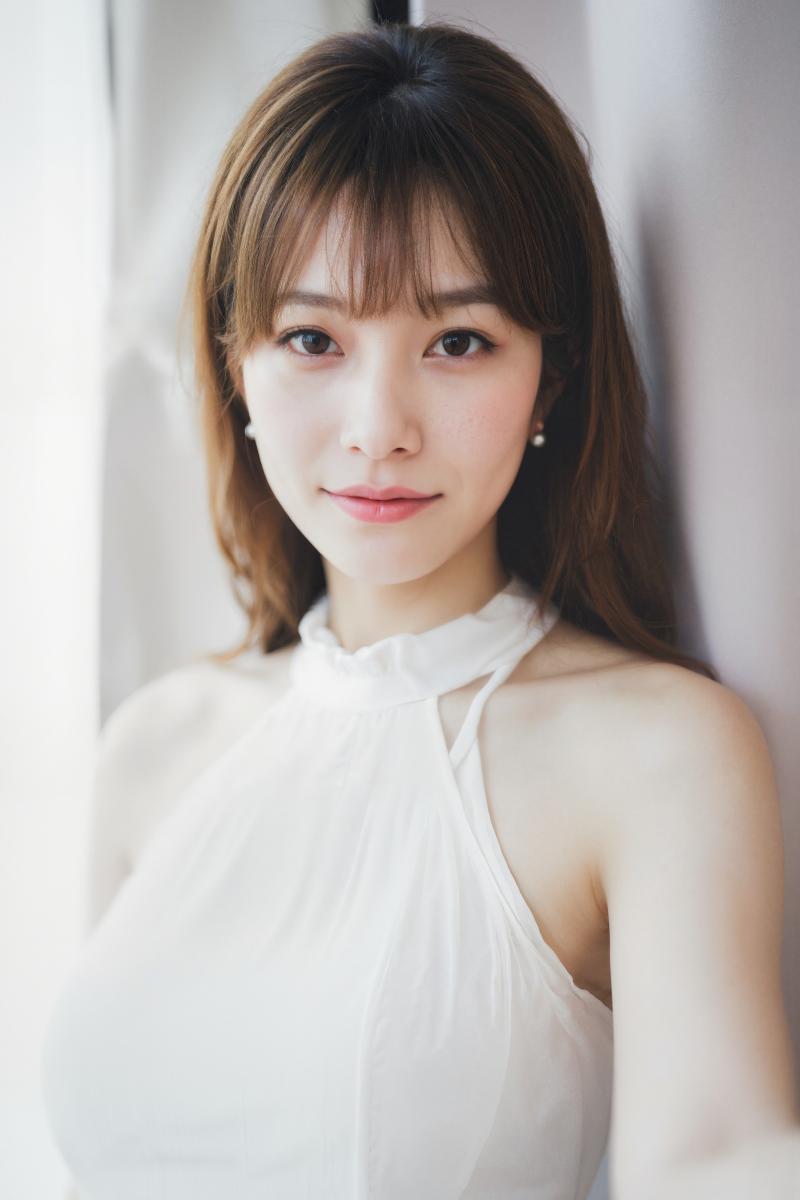 白いノースリーブのトップスを着た、中性的な表情の若い女性のポートレートをポートレート...。