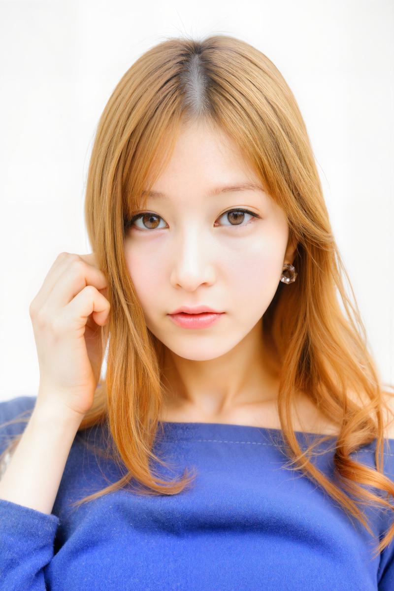 ウェーブのかかった明るい茶色の長い髪と茶色の目をした、青いオフショルダー セーターを...。