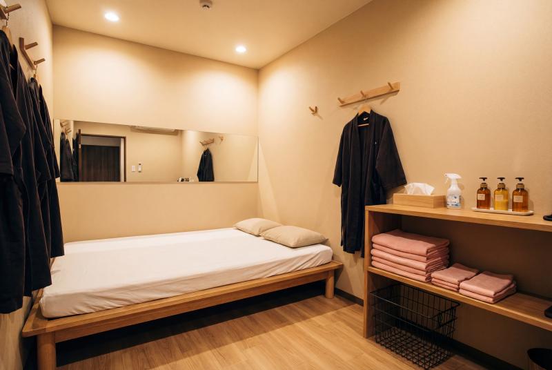 部屋の中央に木製のベッドフレームと白いリネンを備えたシンプルなベッドルーム。