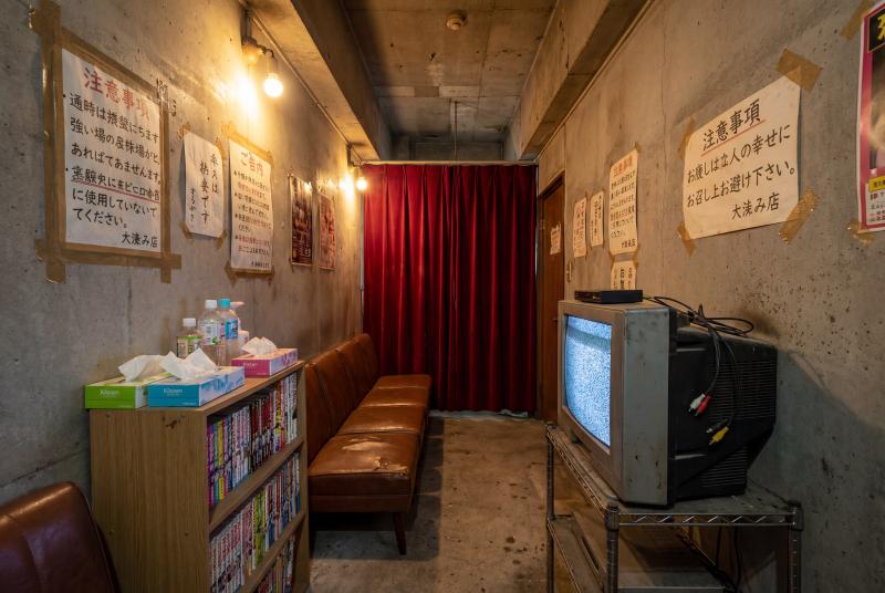 コンクリートの壁と赤いカーテンのある薄暗い部屋。