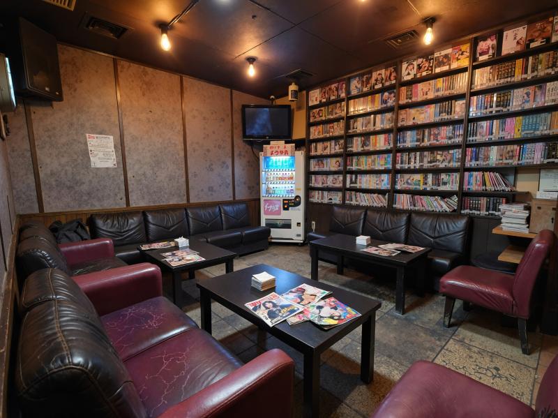 部屋の中央にあるコーヒーテーブルを中心に、黒革張りのソファと赤い革張りの椅子が半円状...。