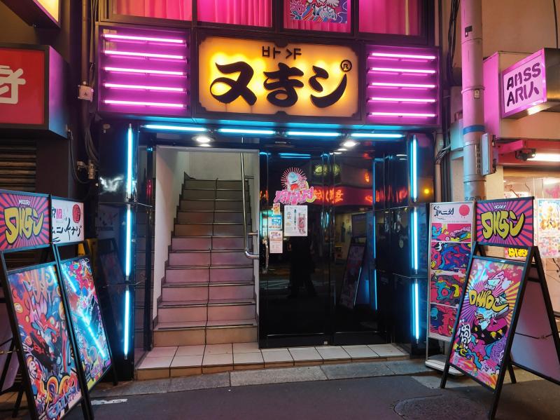 都会の中に佇む日本料理店「ass aru」のネオン輝く入口の写真。