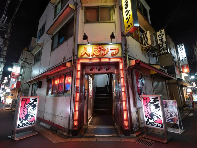 夜の料亭の入り口をローアングルから見上げた写真。