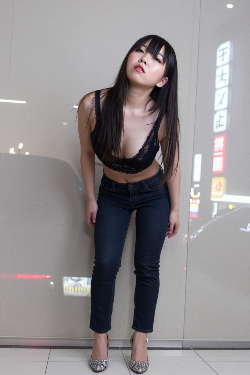 黒いレースのクロップトップとダークブルーのジーンズを着て、ガラスの壁に向かって自信を...。